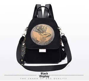 Detail of black faux suede backpack with golden deer head relief and studded charm strap