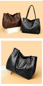 Detail of silver N-shaped metal hardware on textured leather tote bags in black and brown