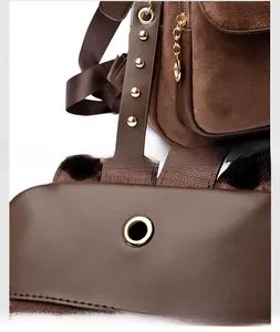Detail of suede backpack featuring gold hardware, metal zipper, and a built-in earphone port
