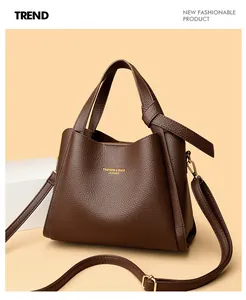 Dettaglio borsa a secchiello in pelle marrone scuro con grana litchi e logo in oro lucido