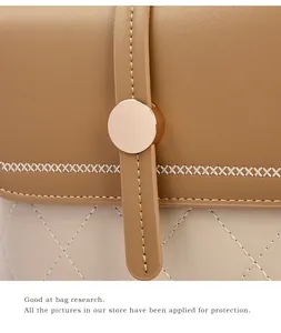 Detail van gewatteerde leren emmertas met gouden hardware en tweekleurige stiksels