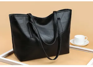 Close-up of black woven leather tote bag with geometric stitching on soft litchi texture