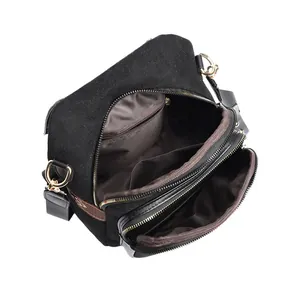 Black suede crossbody backpack with multi-layer interior and gold hardware detail