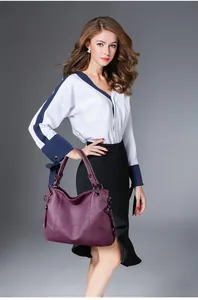 Détail du sac à main en cuir violet avec coutures géométriques et gland décoratif