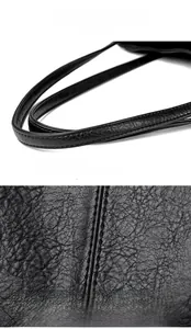 Detailed macro view of litchi grain leather texture and neat stitching on black tote bag