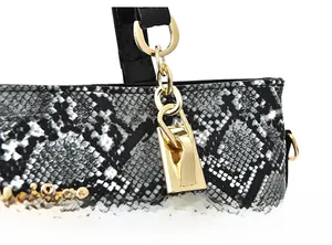 Detail shot of the snake pattern handbag featuring gold-tone hardware and metal logo