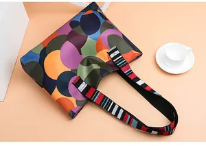 Detail of large tote bag featuring colorful dot prints and striped woven handles