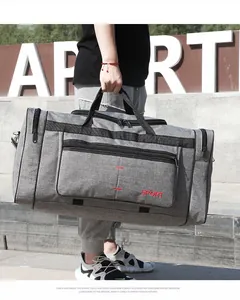 Détail du sac de voyage de sport gris en tissu imperméable avec logo SPORT rouge