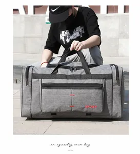 Détail du grand sac de sport gris avec broderie sport sur des marches en pierre extérieures