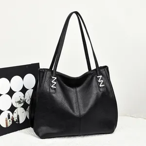 Minimalist black leather tote bag with silver metal accents and long shoulder straps