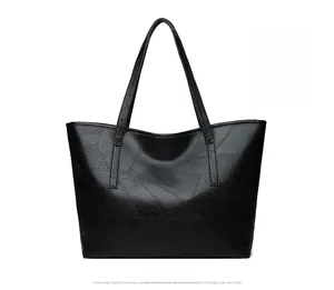 Detail of black woven leather tote bag featuring modern geometric patchwork design