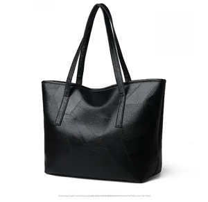 Detailed close-up of a black woven leather tote bag with a textured pebble finish