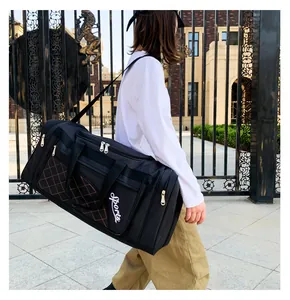Quilted diamond pattern pocket and sports lettering detail on black duffel bag