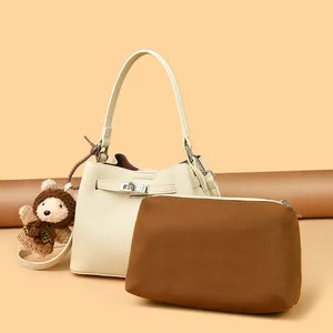 Retro bucket handbag in cream pebbled leather with silver lock and plush bear charm