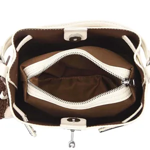 White leather bucket bag featuring a brown interior with central zipper compartment