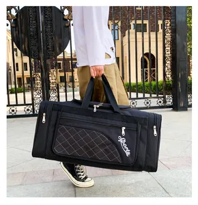 Close-up of black sports duffle bag featuring quilted pocket and white embroidery