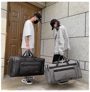 Détail de grands sacs de voyage sport noir et gris montrant le tissu et les crochets