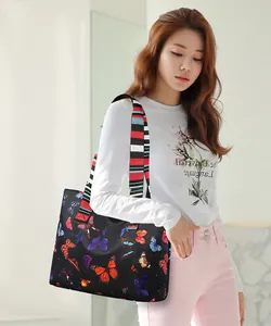 Detail of oxford tote bag with colorful butterfly prints and striped webbing strap