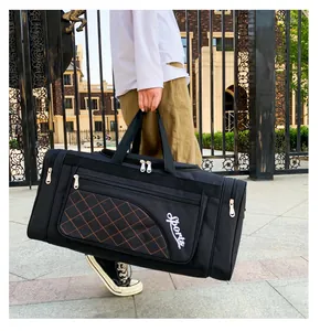 Outdoor shot of a black quilted travel bag with Sports lettering and double handles