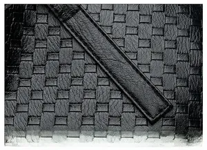 Close-up of black woven leather texture and precise stitching on casual shoulder bag