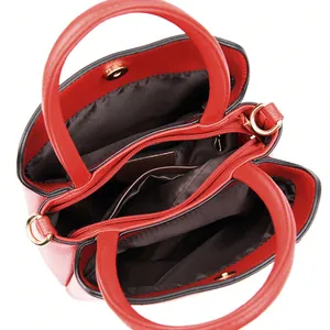 Red pebbled leather bucket bag with triple compartments and golden hardware interior detail