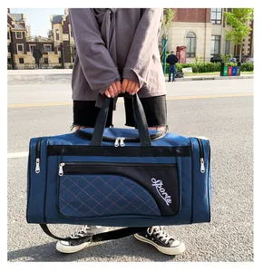 Blue quilted travel duffel bag with Sports logo and side zipper pockets for gym use