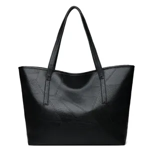 Large black woven leather tote bag with geometric stitching and slim shoulder straps