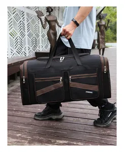 Dettaglio della borsa da viaggio nera con tasche laterali e finiture marroni all'aperto
