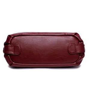 Vue du bas du sac à main en cuir véritable rouge foncé avec surpiqûres renforcées