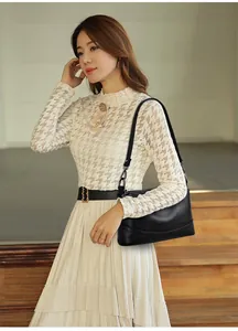 Modelo de moda con un bolso de hombro tipo cubo en cuero de oveja color negro