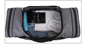 Top view of open grey sports gym bag showing large interior capacity with travel items