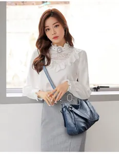 Dettaglio della borsa a tracolla in pelle blu scuro con trama vintage e rivetti in metallo