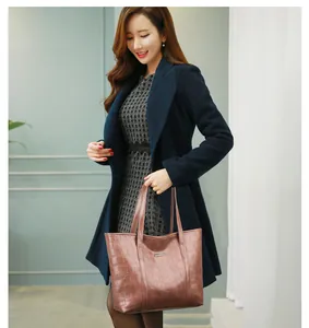 Detail of dark brown stone pattern tote bag carried by woman in a navy coat