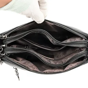 Bolso bombonera de piel negra con tres compartimentos con cremallera y cadena de plata