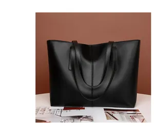 Primer plano de un bolso tote de cuero negro mate con costura vertical para oficina