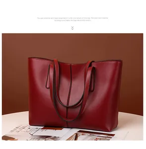 Primer plano detallado de un bolso tote de cuero granate con elegantes costuras verticales