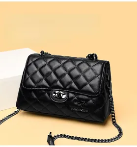 Close-up of black quilted leather texture and metallic clasp on chain strap handbag