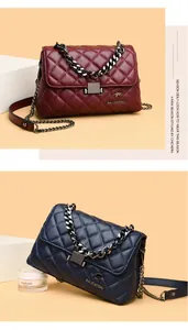 Detail of quilted leather flap bags in burgundy and navy blue with metal chain straps