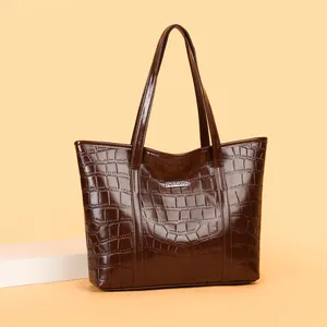 Large dark brown tote bag with crocodile texture and metallic silver brand plaque