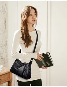 Lifestyle shot of black lychee texture crossbody bag with multiple zip pockets and strap