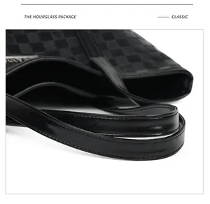 Détail du sac cabas à damier noir montrant les anses en cuir lisse et les coutures fines