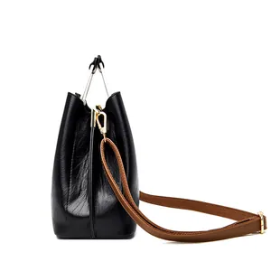 Schicke schwarze Eimertasche mit silbernem Metallgriff und braunem Schultergurt
