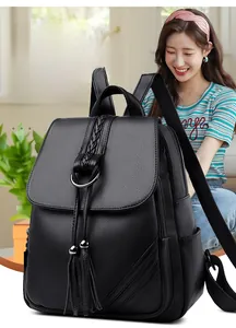 Close-up of black leather backpack with tassel drawstring and metal buckle detail