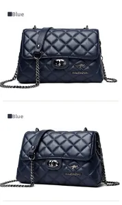 Detail shot of the quilted blue chain bag with a metallic rotary lock and leather strap
