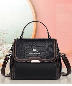 Detail of crocodile-embossed leather texture and metallic kangaroo logo on handbag