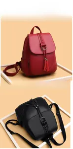 Detail of red and black leather backpacks with fringe tassels and woven accents