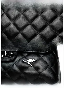 Detailed view of black quilted sheepskin texture and metallic kangaroo logo on the handbag