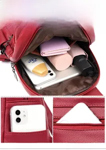 Detail of red leather backpack featuring multi-pocket storage and secure anti-theft zip bag