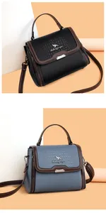 Detail view of crocodile pattern leather handbags in black and grey-blue with metal logos