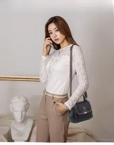 Model wearing a black crocodile pattern shoulder bag with a metal clasp lock detail